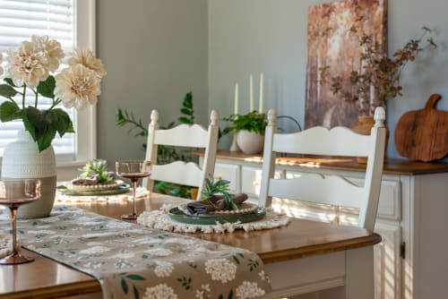 Salle à manger élégante à La Grange Aux Etangs avec chaises blanches, fleurs de dahlia crème et table rustique à Sennely