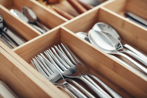 Tiroir de couverts en bois organisé avec fourchettes, couteaux et cuillères à La Grange Aux Etangs