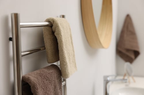Porte-serviettes élégant avec serviettes aux tons neutres dans une salle de bain moderne à La Grange Aux Étangs, un charmant gîte