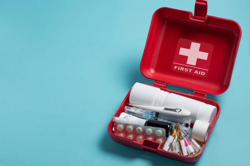 Trousse de secours rouge ouverte sur fond bleu à la Grange Aux Étangs, gîte à Sennely, France