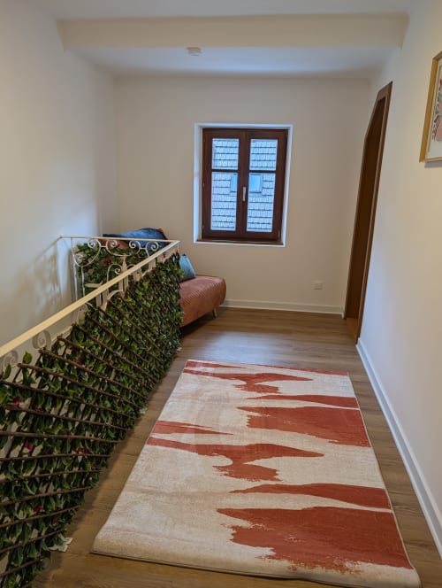 Bright hallway at Bi d'Grosseltere cottage in Kirrwiller with ivy-covered railing, modern window, red patterned rug, and
