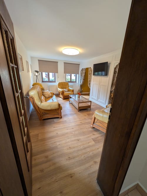 Spacious living room at Bi d'Grosseltere cottage with comfortable seating, wooden flooring, and garden views in Kirrwiller