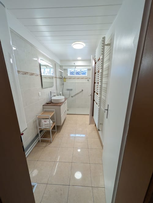 Modern accessible bathroom at Bi d'Grosseltere in Kirrwiller with walk-in shower, vessel sink, and heated towel rack