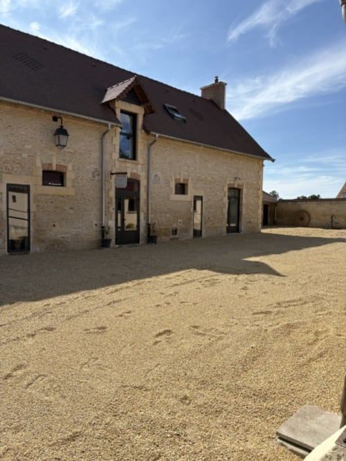 Maison en pierre du Domaine Du Grand Fort en Normandie avec cour de gravier et vue sur le jardin