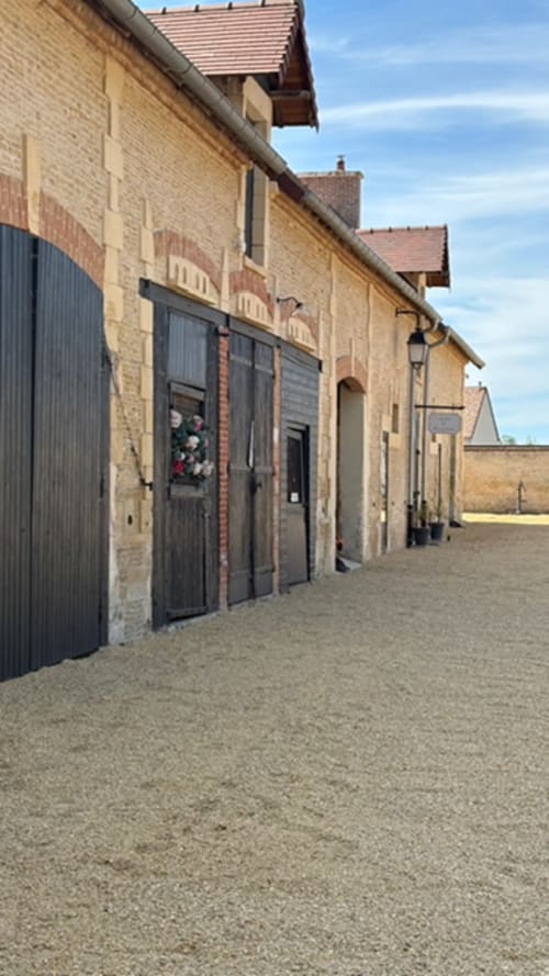 Charmantes maisons en pierre aux portes noires du Domaine Du Grand Fort, gîte collectif à Banneville la Campagne, France.