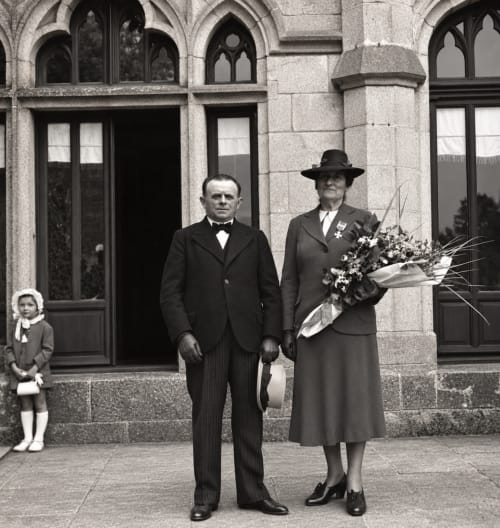Portrait de gala vintage au domaine historique près de Limoges, invités en tenue d'époque élégante avec fleurs