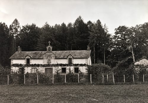 Chapelle historique blanche avec croix au gîte Domaine de Bort près de Limoges, entourée d'arbres et de campagne