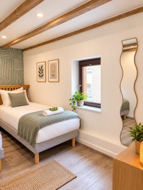 Chambre moderne chez Mattbnb Metz avec poutres apparentes, vue sur la ville, décoration contemporaine en quartier cathédral