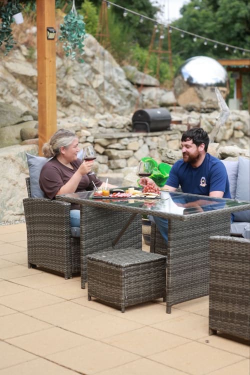 Couple enjoying wine and charcuterie on patio at Greenvale Cabins, Newry with stone features