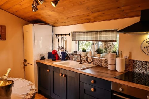 Warm kitchen in Colorado Apartment at Greenvale Cabins Newry with wood beams, black cabinetry, and mountain views