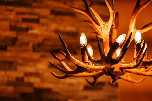 Rustic antler chandelier with glowing candles at Greenvale Cabins mountain apartment in Newry