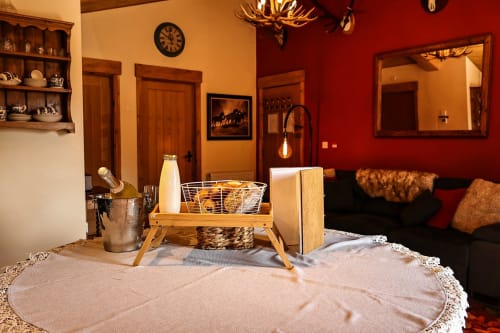 Cozy Colorado Apartment sitting area at Greenvale Cabins Newry, with warm amber walls, wooden furnishings, and mountain view