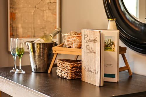 Greenvale Cabins welcome package with wine glasses and hospitality items on dark table in Slieve Gullion Apartment, Newry