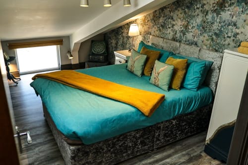 Turquoise bed with gold accent in Slieve Gullion Apartment at Greenvale Cabins, Newry, featuring mountain views and modern