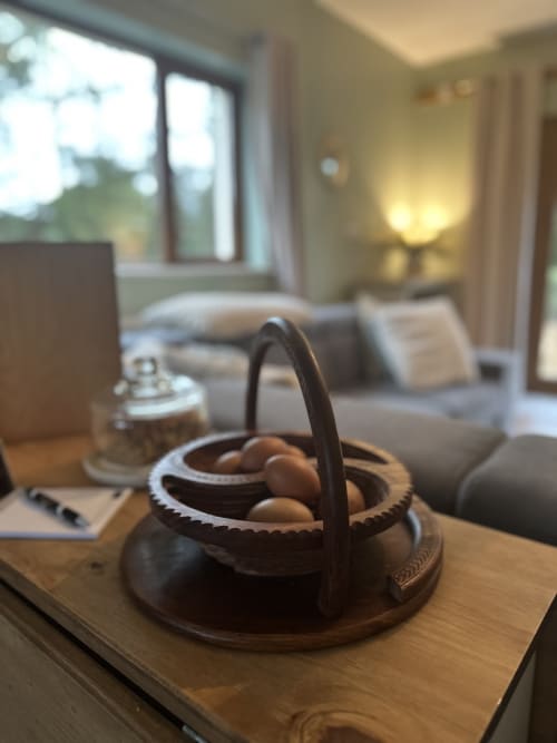 Wooden basket with eggs and handle at Greenvale Apartment cottage in Newry, with garden views and sitting area in background