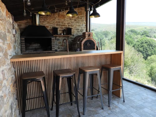 Rústico bar con mostrador de madera y taburetes con vistas al paisaje montañoso de Burgos en Hotel Rural Izarbe