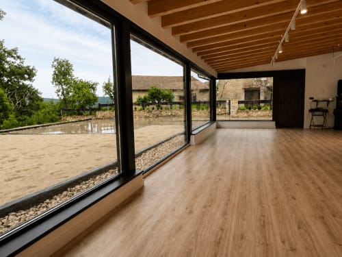 Interior de cabaña moderna en Hotel Rural Izarbe de Burgos con suelos de madera y ventanales panorámicos con vistas a la montaña