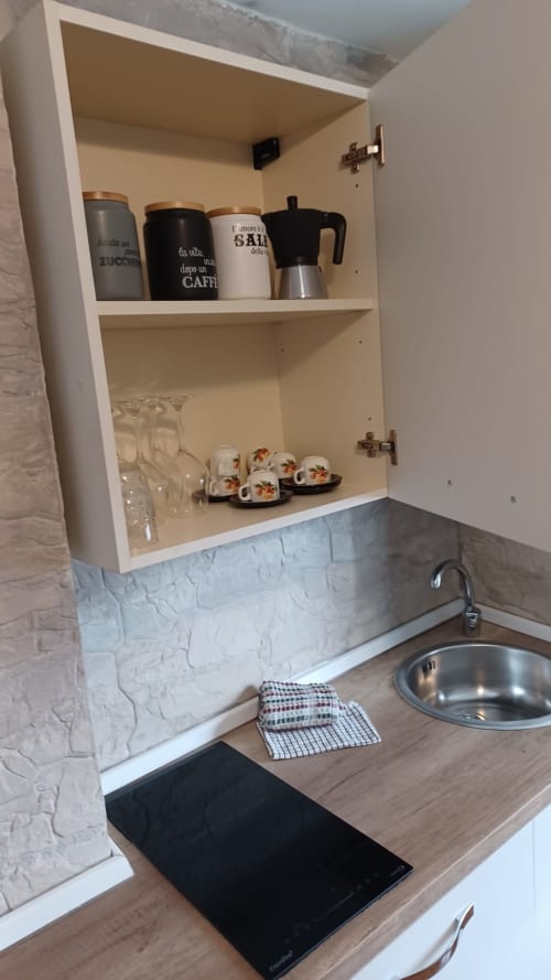 Credenza della cucina in Appartamento Sormano presso THE V Collection Milano, con caffettiere, tazze e bicchieri sopra