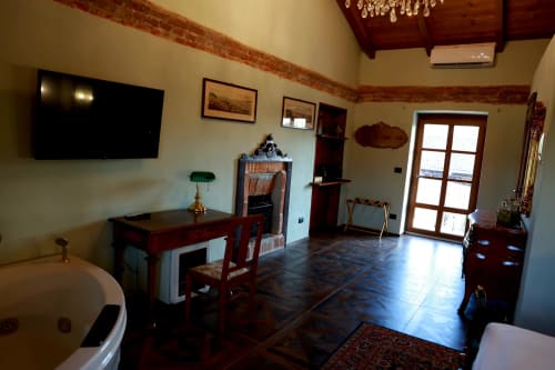 Suite di B&B Cascina Tavella a Rivalta di Torino con scrivania in legno, TV a schermo piatto e vista montagne dalle porte vetrate