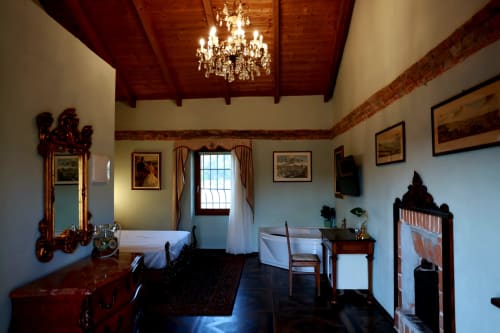 Elegante suite presso B&B Cascina Tavella a Rivalta di Torino con soffitto in legno, lampadario in cristallo, arredi d'epoca e
