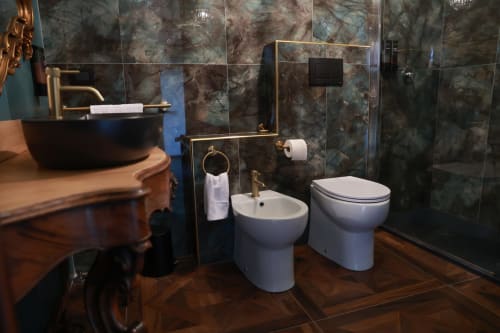 Suite bagno di lusso presso B&B Cascina Tavella con marmo nero, bidet, wc, lavabo e doccia walk-in
