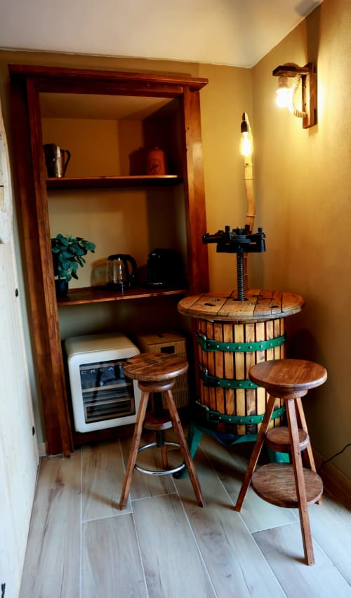 Rustica sala botti di vino presso B&B Cascina Tavella con sgabelli in legno, scaffalature e illuminazione calda