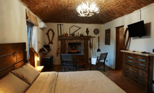 Camera rustica con camino, soffitto in mattoni a vista e comfort moderni presso B&B Cascina Tavella a Rivalta di Torino