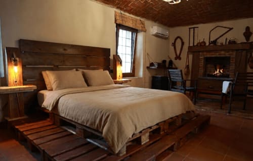 Camera rustica presso B&B Cascina Tavella con letto in legno, camino e illuminazione calda a Rivalta di Torino