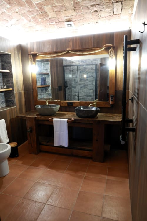 Bagno rustico del B&B Cascina Tavella con doppi lavabi in ceramica, mobile in legno e doccia in pietra