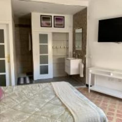 Moderno dormitorio en apartamento de Santa Cruz de Tenerife con vistas a la ciudad, cama, armario, TV y baño privado
