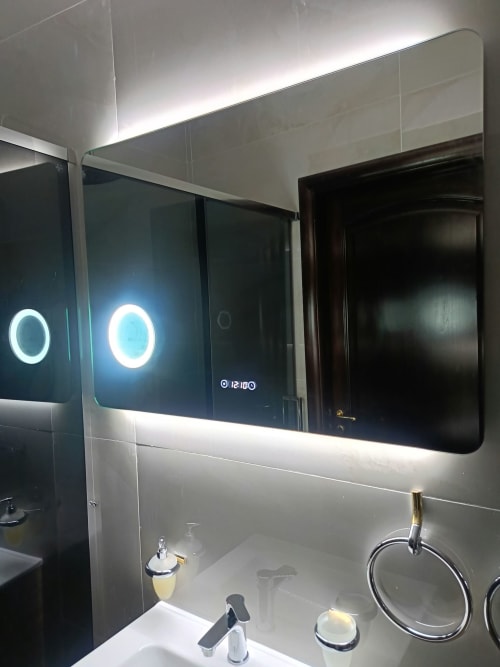 Specchio moderno del bagno con illuminazione LED presso l'hotel Atena Smartrooms a Sellia, con doppi cerchi illuminati e display digitale