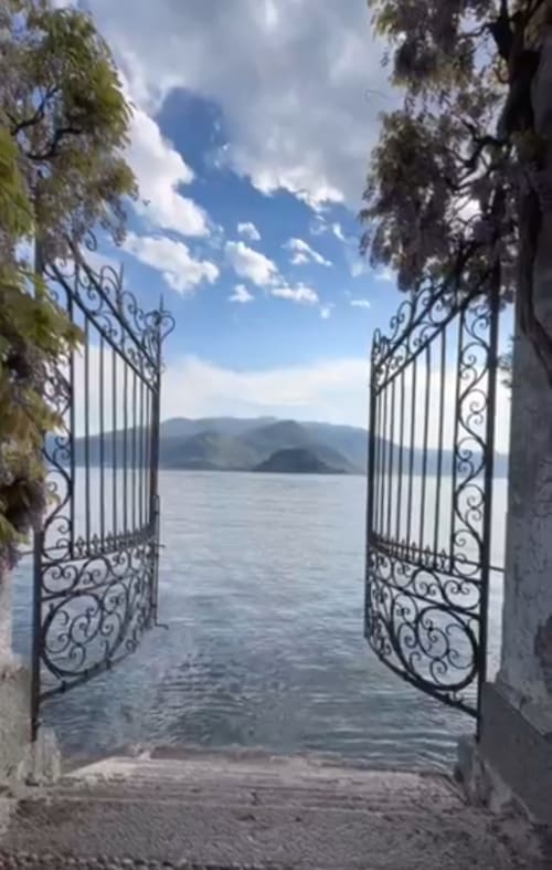 Ornate wrought iron gates opening to Lake Como view from Villa Vista Lago di Como in Bellano