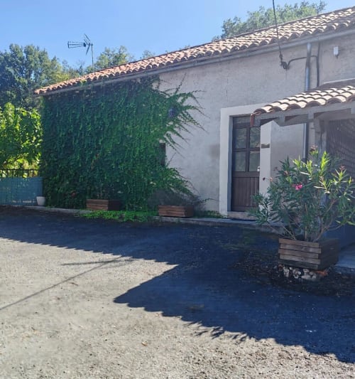 Cottage Le Cantou aux Gites De Petrocoriis, murs couverts de lierre, toit en terre cuite et entrée jardin à Boulazac