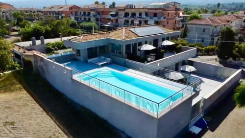 Vista aerea di Aurora View Resort con due piscine, zone lounge e architettura mediterranea a Mascali, Italia