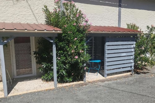 Le gîte Le Laurier Rose aux Gites De Petrocoriis à Boulazac avec fleurs roses et patio couvert
