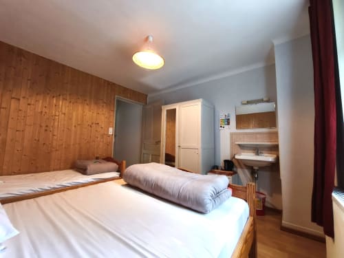 Chalet Coste Belle 3-person bedroom in Ceillac with wooden walls, white bedding, and mountain views