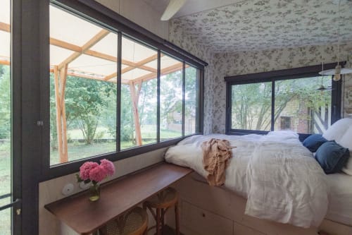 Moderne slaapkamer met tuinuitzicht in villa Domaine de Blanvatel, grote ramen, houten balken, eigentijds ontwerp