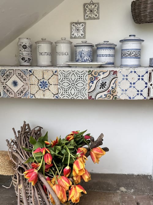 Mensola decorativa con vasetti in porcellana e piastrelle decorate, fiori freschi in vaso rustico, arredamento camera Relais Palazzo Cacace