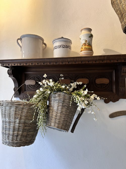 Elegante scaffale in legno con pregiati vasi in porcellana e fiori bianchi in cesto di vimini al Relais Palazzo Cacace