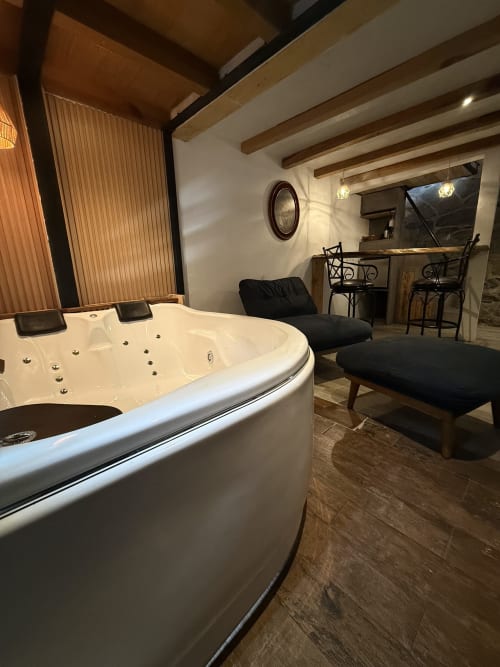 Lujosa sala de spa en Casa Acento, Valle de Bravo, con bañera de hidromasaje, área de descanso y acabados rústicos