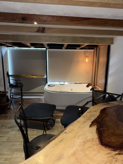 Moderna zona spa de la cabaña CASA ACENTO Valle de Bravo con tina de hidromasaje, asientos y techo de vigas aparentes