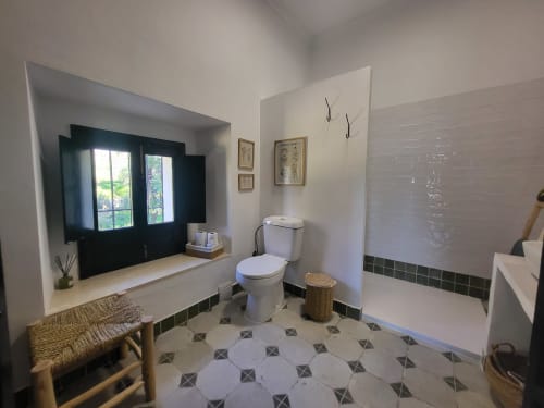 Baño moderno en Hacienda Las Lumbreras de Montellano con sanitarios blancos, piso de azulejos geométricos y tocador integrado