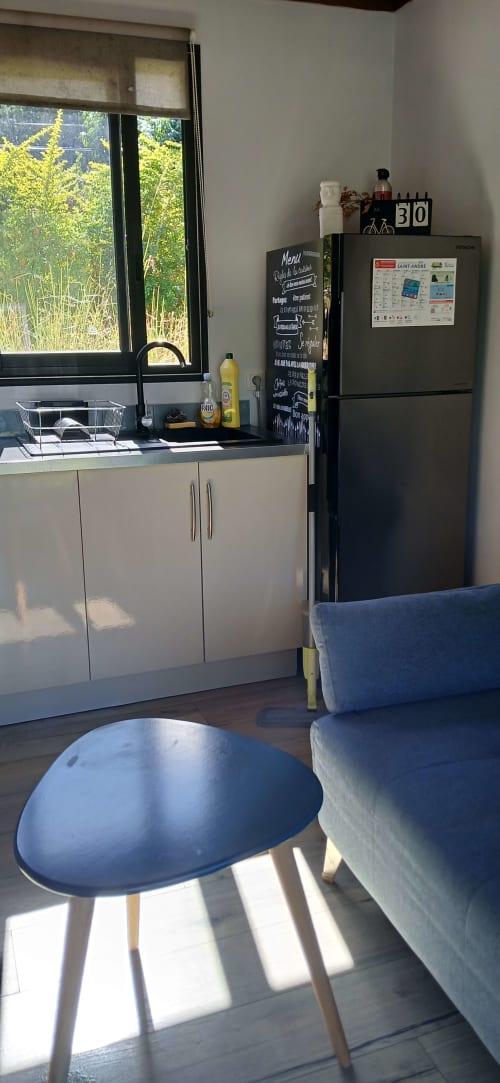 Cuisine moderne du Chalet Eléonore au Domaine de Jade à Saint-André, avec réfrigérateur noir et coin repas