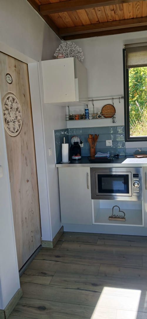 Petite kitchenette du Chalet Eléonore au Domaine de Jade, Saint-André, avec placards blancs, carrelage bleu, micro-ondes et