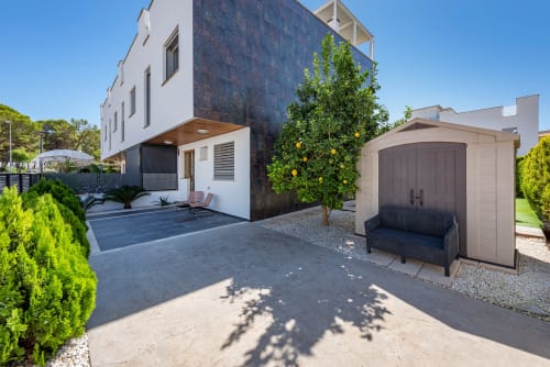 Modern villa in Alcudia with private pool, patio seating, lemon tree, and attached garage on sunny day