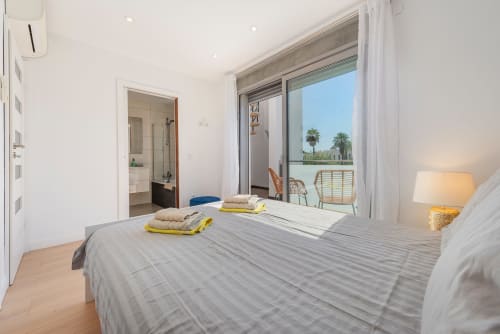 Modern bedroom in MallorcaWeek villa Acacias, Alcudia, with pool views through sliding doors and furnished terrace