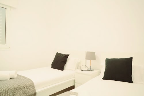 Camas gemelas con almohadas oscuras y lámpara de noche en el apartamento Royal Banus, Marbella