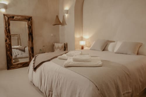 Chambre minimaliste sereine à EntreArcos Eco-Boutique à Vejer de la Frontera avec literie crème, miroir en bois et ambiance chaleureuse