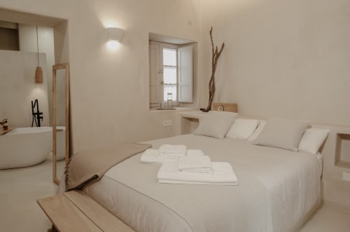 Chambre minimaliste à EntreArcos Eco-Boutique, Vejer de la Frontera, avec draps blancs, accents bois et salle de bain attenante