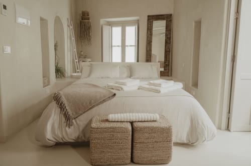 Chambre sereine à EntreArcos Eco-Boutique à Vejer de la Frontera avec literie neutre, poufs tressés et lumière naturelle
